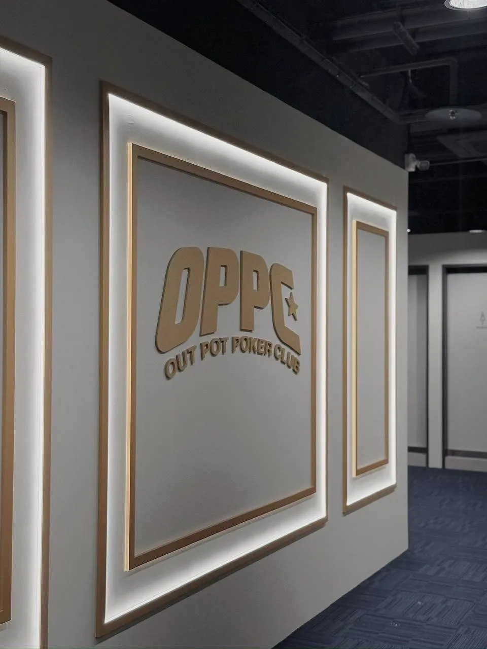 OPPC 的走廊，牆面上一連三面發光邊框裡的協會標誌