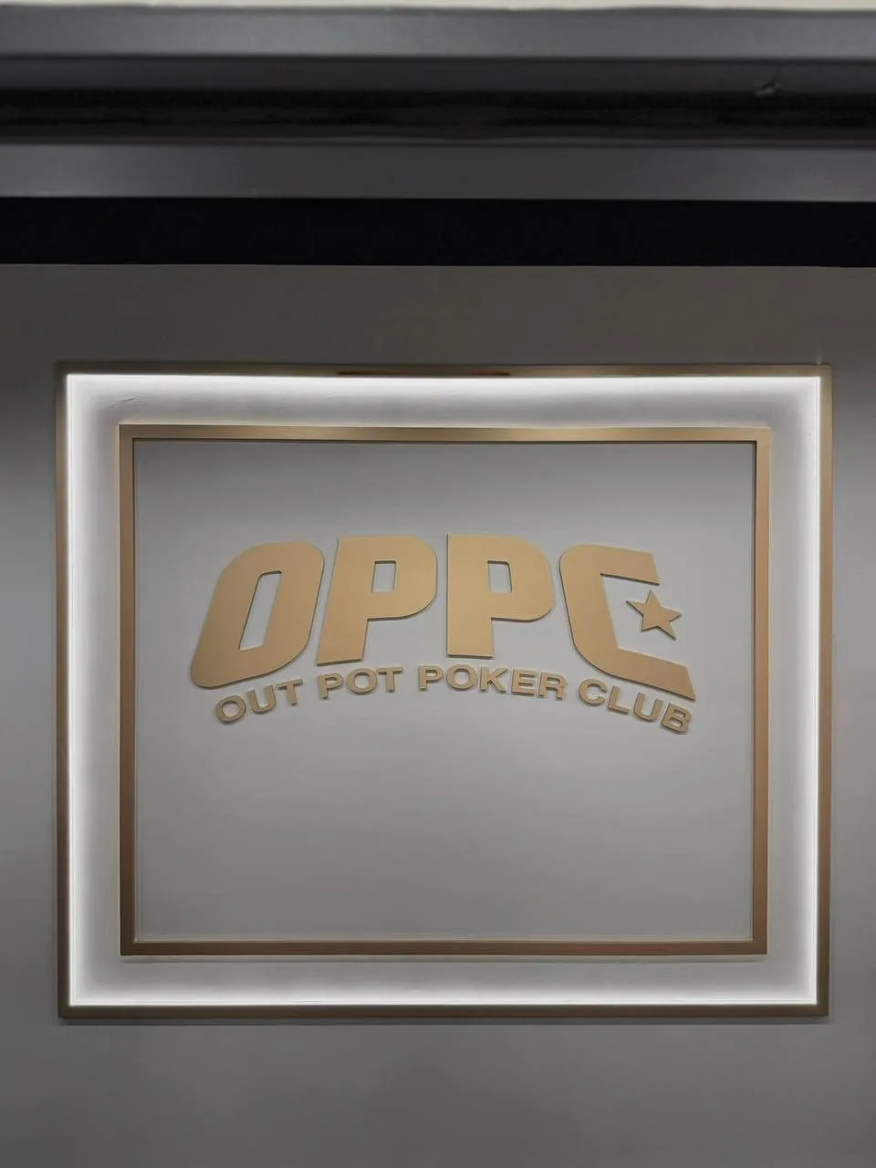 OPPC 入口牆面上的發光標誌，寫著 OUT POT POKER CLUB