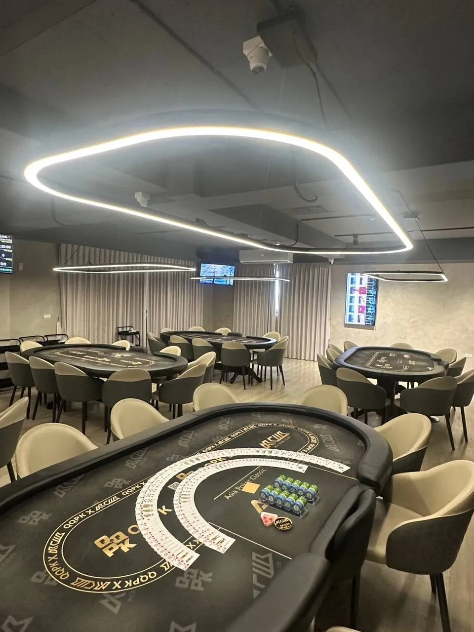 Ace King Club 宜蘭分會的主賽場，多張牌桌排開，天花板是環繞的線形燈